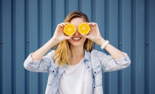 Woman with oranges up to her eyes e1569882403131